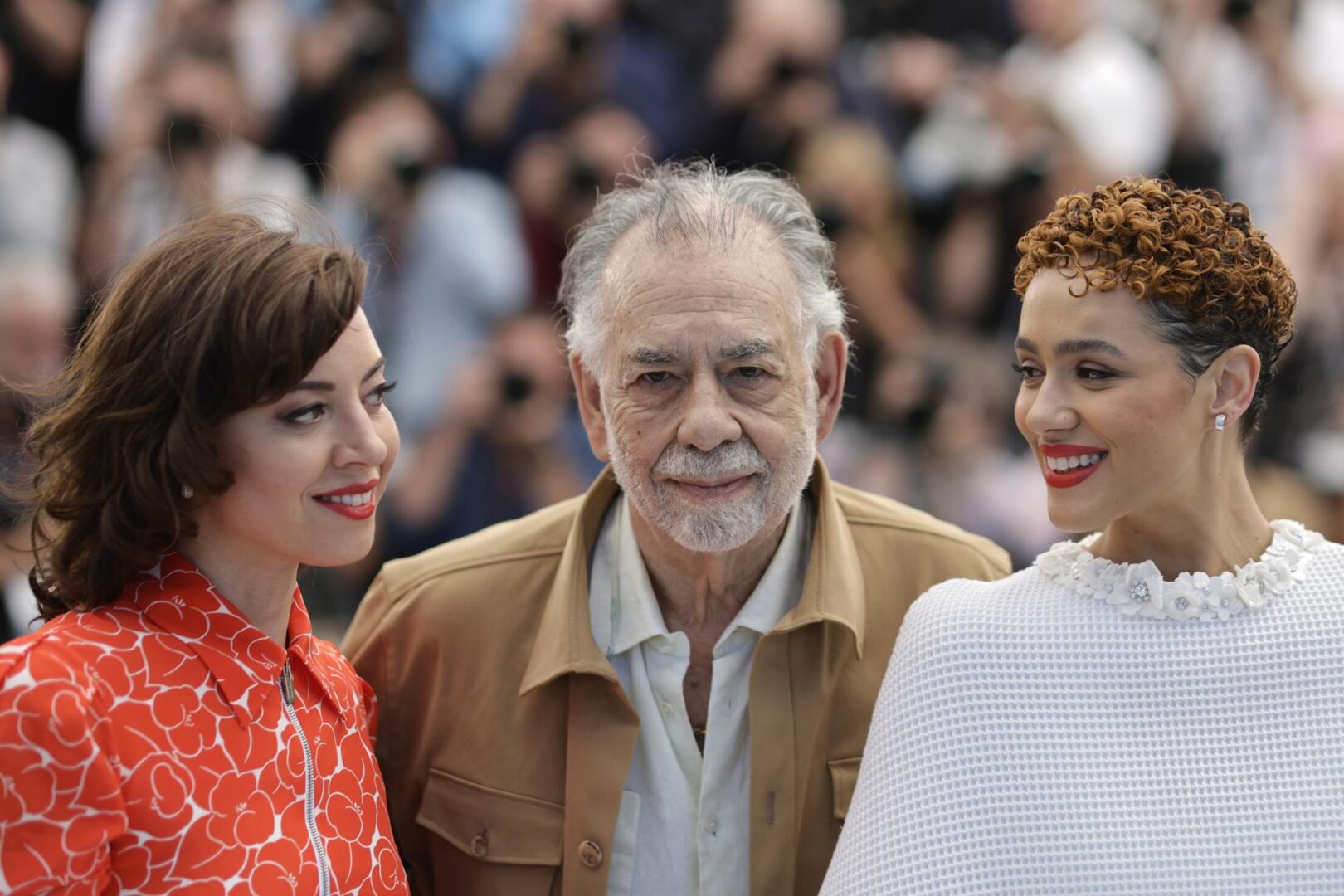 Las actrices Aubrey Plaza y Nathalie Emmanuel rodeando al director Francis Ford Coppola