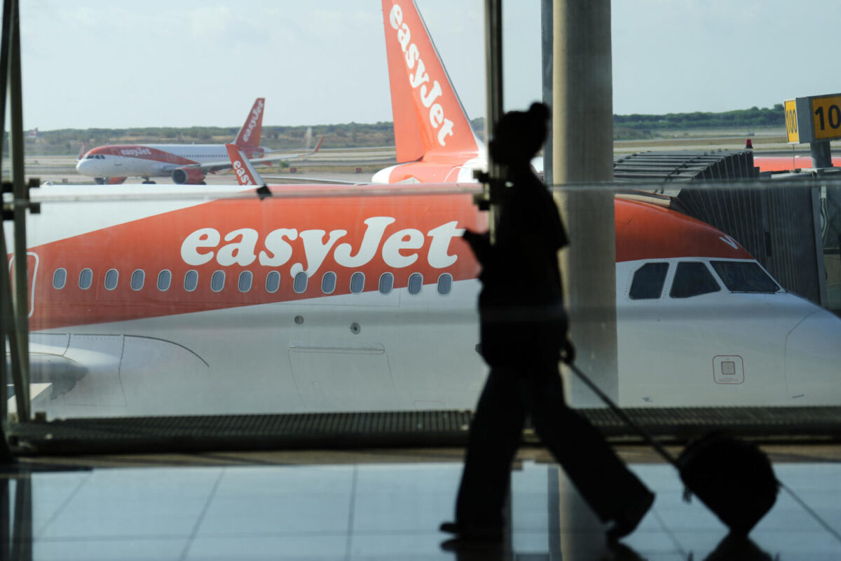 Una pasajera mientras pasa delante de un avión de la aerolínea easyJet en el Aeropuerto de El Prat de Barcelona