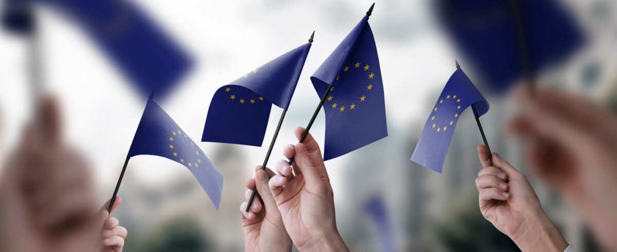 Un grupo de personas con banderas de la Unión Europea en sus manos.