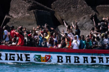 Un grupo de migrantes celebra haber sobrevivido a una travesía de siete días desde Senegal a la isla española de El Hierro cuando ingresan al puerto de La Restinga el jueves 22 de agosto.