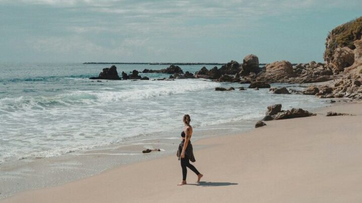 mujer en la playa paseando sola