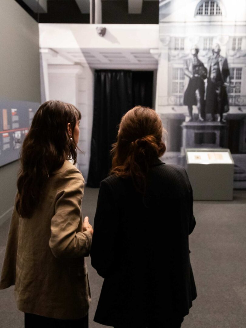 Dos visitantes en la sala ilustrativa sobre la República de Weimar, con los poetas Goethe y Schiller al fondo