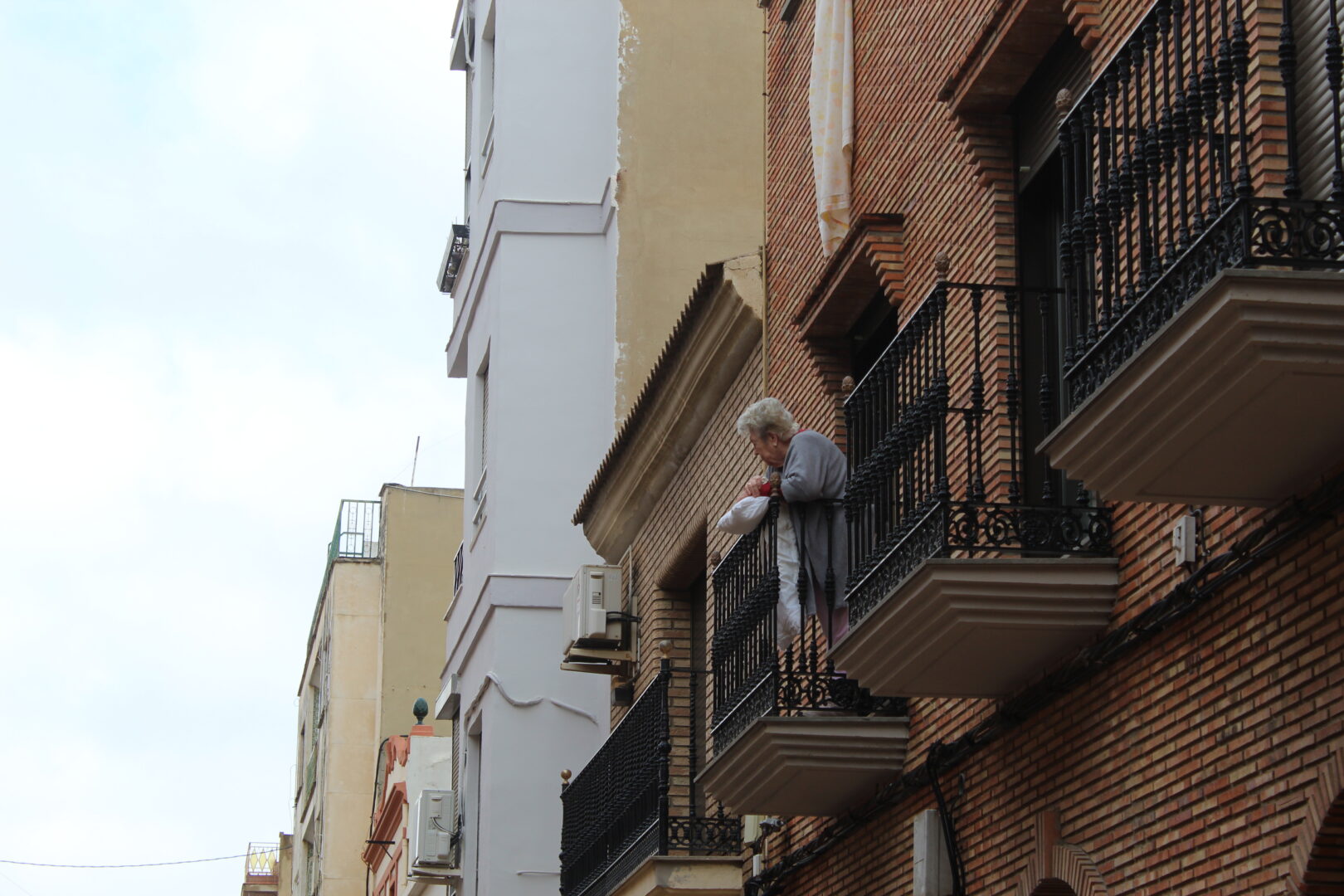 Una vecina mayor mira desde su balcón a los militares en Paiporta