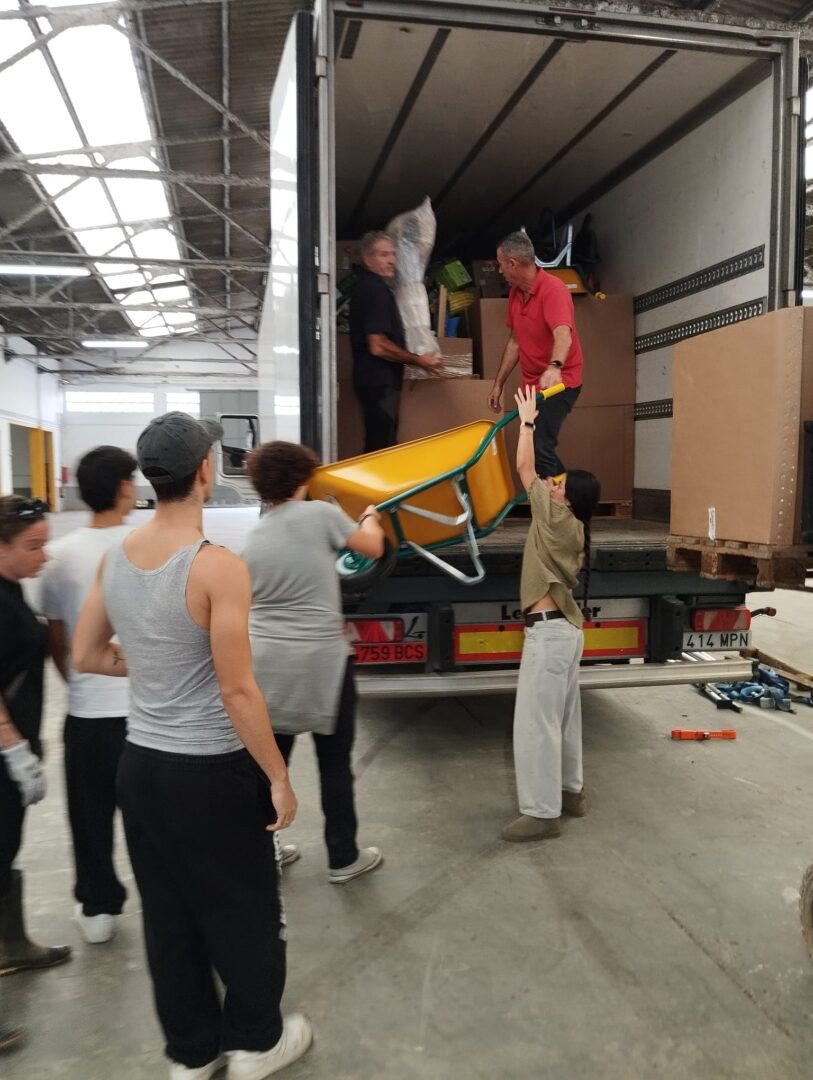 Los voluntarios, descargando uno de los tráilers en el albergue CSM